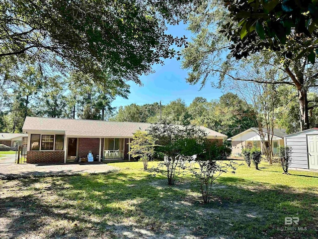 view of front facade with a storage shed and a front lawn