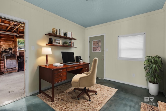 home office featuring wooden walls, plenty of natural light, and ornamental molding