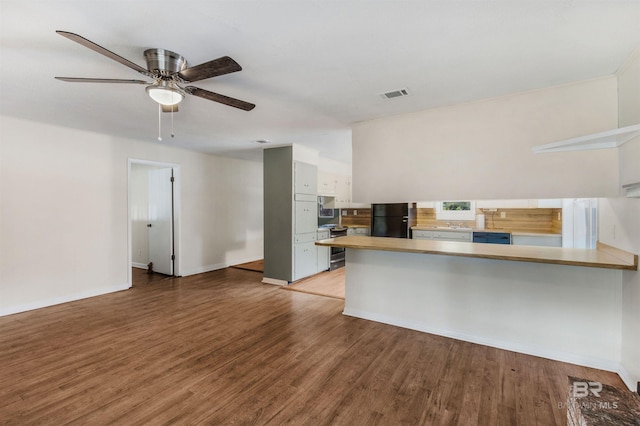 kitchen featuring kitchen peninsula, hardwood / wood-style floors, black fridge, and ceiling fan