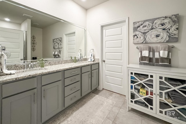 bathroom featuring visible vents, a sink, and double vanity