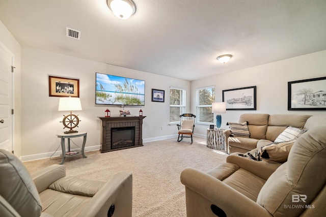 carpeted living area featuring a brick fireplace, visible vents, and baseboards