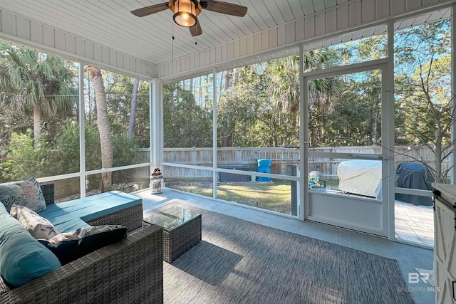 sunroom / solarium featuring a ceiling fan