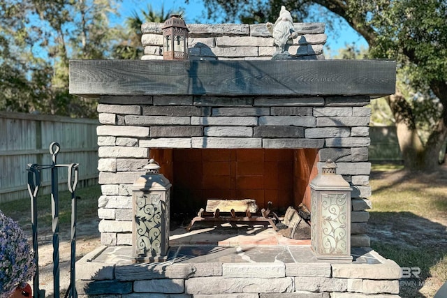 details featuring fence and an outdoor fireplace