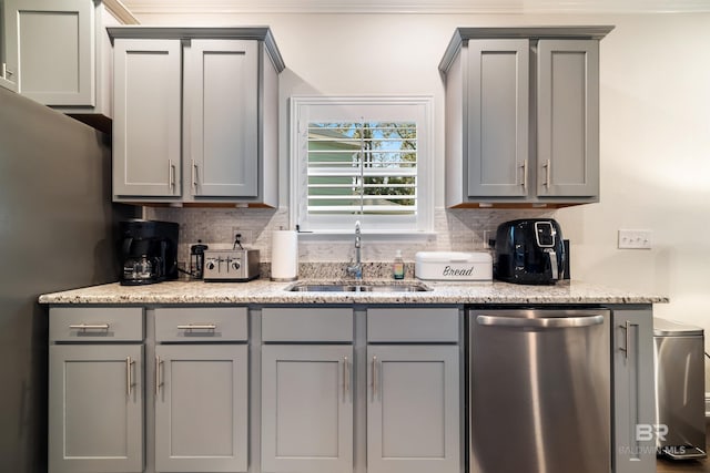 kitchen featuring a sink, stainless steel dishwasher, gray cabinets, and decorative backsplash