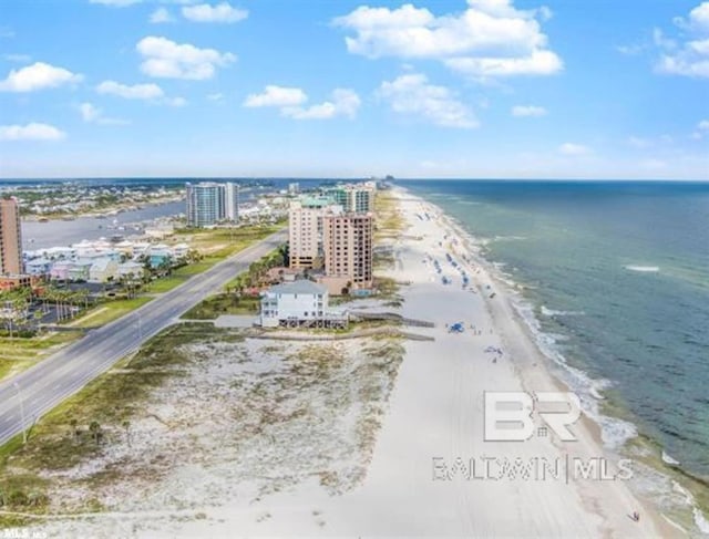 drone / aerial view featuring a water view, a beach view, and a city view