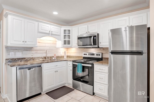 kitchen with crown molding, white cabinets, tasteful backsplash, and stainless steel appliances