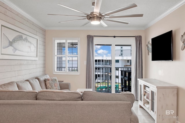 living room with tile flooring, ceiling fan, a textured ceiling, and crown molding