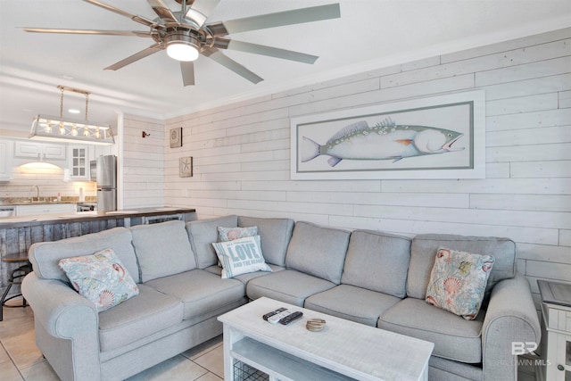 tiled living room with sink, wooden walls, and ceiling fan