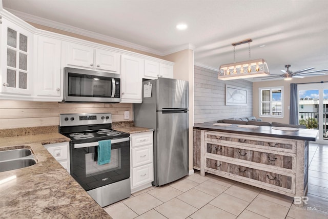 kitchen with white cabinets, ornamental molding, ceiling fan, and stainless steel appliances