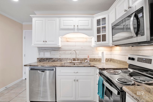 kitchen with appliances with stainless steel finishes, white cabinetry, sink, and light stone countertops