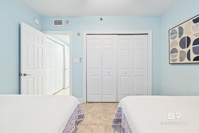 tiled bedroom with a closet