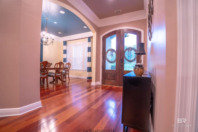 foyer featuring ornamental molding, french doors, hardwood / wood-style floors, and a chandelier