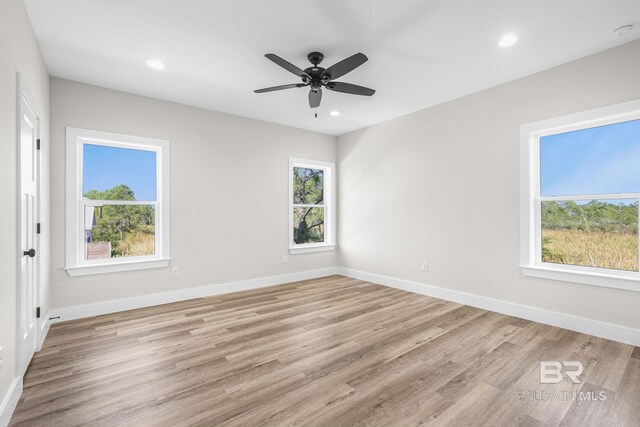 unfurnished room featuring ceiling fan, light hardwood / wood-style floors, and a healthy amount of sunlight