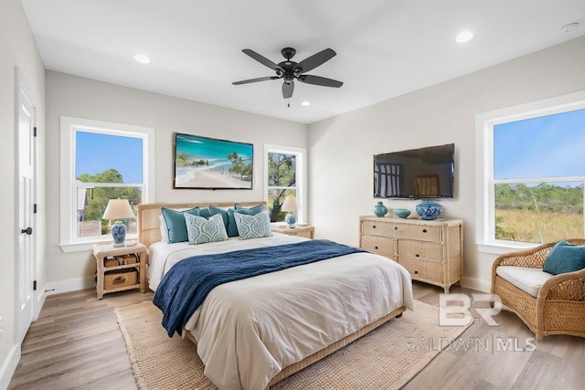 bedroom with light hardwood / wood-style flooring, multiple windows, and ceiling fan