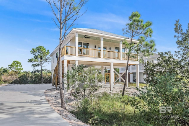 coastal inspired home featuring ceiling fan and covered porch