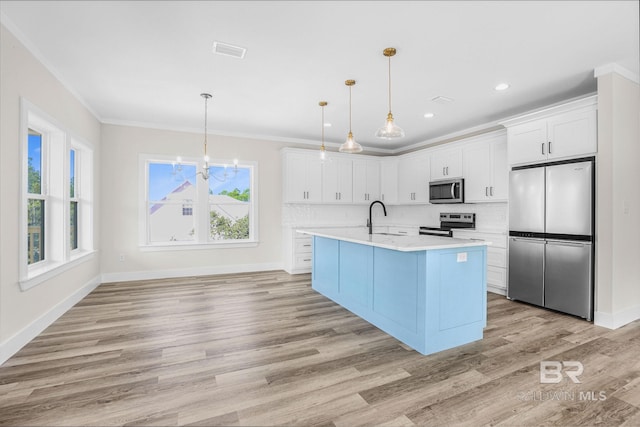 kitchen with decorative light fixtures, stainless steel appliances, light hardwood / wood-style floors, and white cabinetry