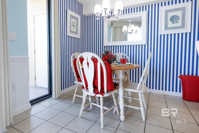 dining area with wallpapered walls, an inviting chandelier, baseboards, and tile patterned flooring