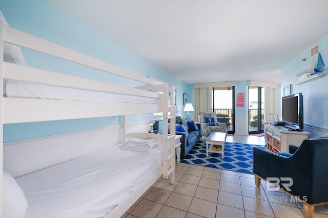 bedroom featuring light tile patterned floors, french doors, and visible vents