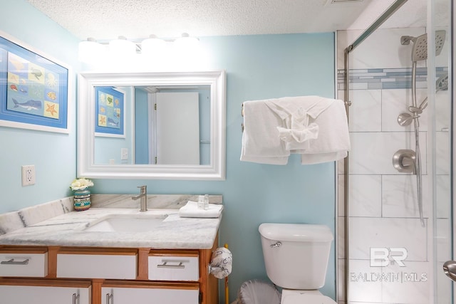 bathroom with vanity, toilet, a stall shower, and a textured ceiling