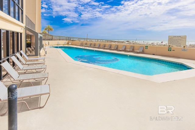 pool with a patio and fence