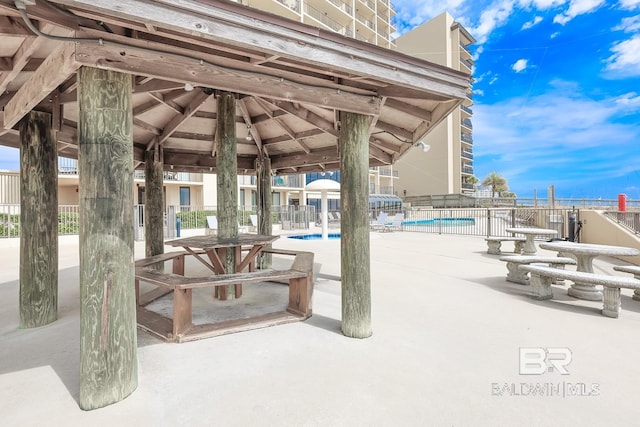 community pool with a patio area and fence