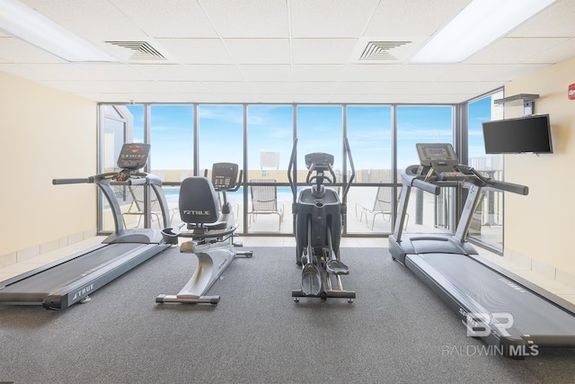 workout area with a wealth of natural light, visible vents, and floor to ceiling windows