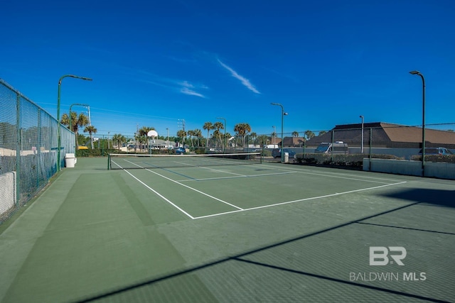 view of tennis court featuring fence