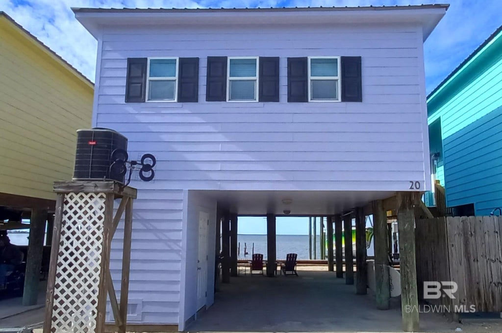 exterior space with a carport, metal roof, and fence