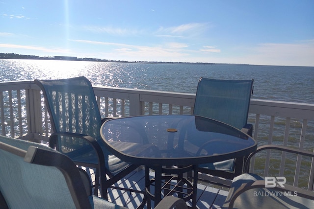 deck featuring outdoor dining area and a water view