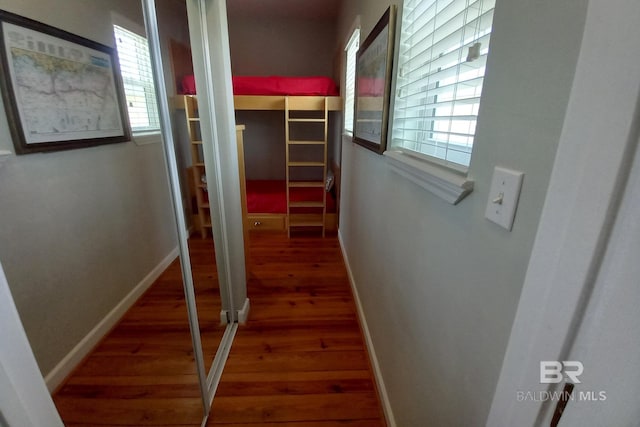 hallway featuring baseboards and wood finished floors