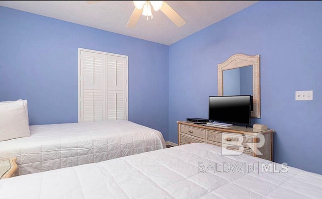 bedroom featuring a closet, ceiling fan, and a textured ceiling