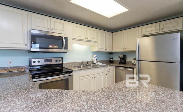 kitchen featuring white cabinets, appliances with stainless steel finishes, and sink