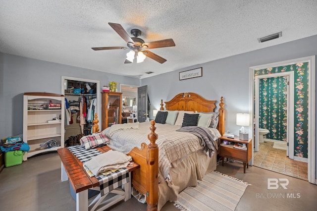 bedroom with a walk in closet, a closet, visible vents, and a textured ceiling