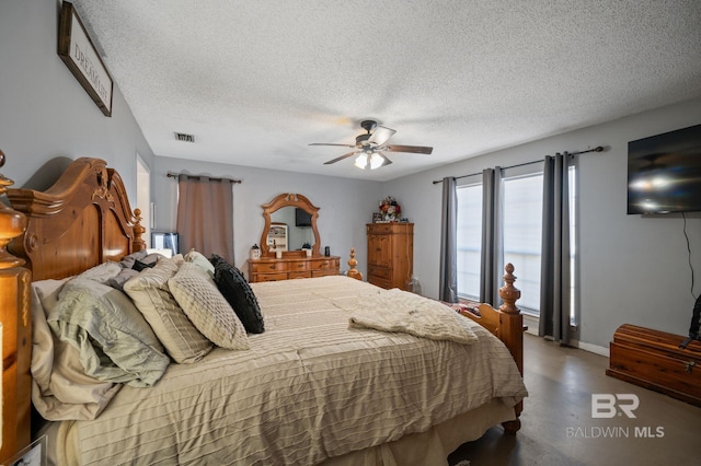 bedroom featuring ceiling fan, a textured ceiling, visible vents, baseboards, and finished concrete flooring