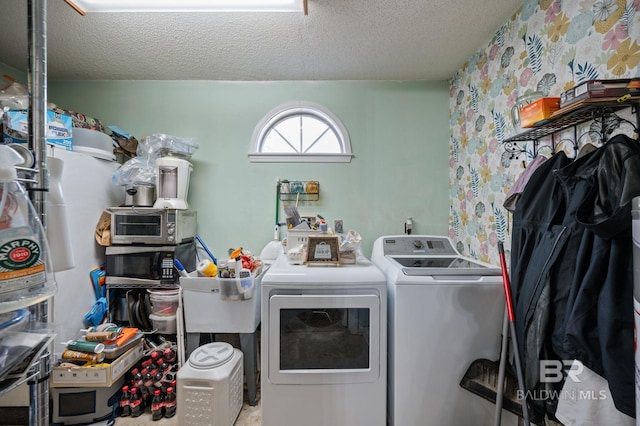 laundry room with a textured ceiling, laundry area, and washer and clothes dryer