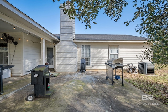 back of house featuring a chimney, cooling unit, and a patio