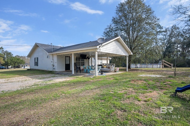 back of property featuring a patio, a yard, and roof with shingles