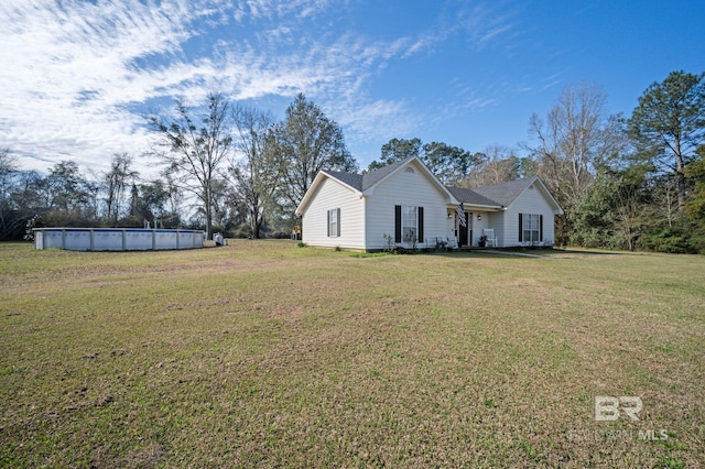 view of front of house featuring an outdoor pool and a front lawn