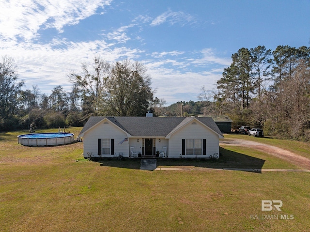 view of front of house with dirt driveway, a front lawn, a chimney, and an outdoor pool