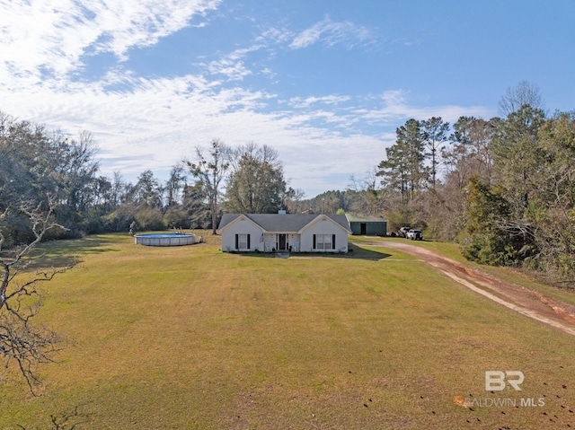 view of front of property with a front yard, an outdoor pool, and dirt driveway