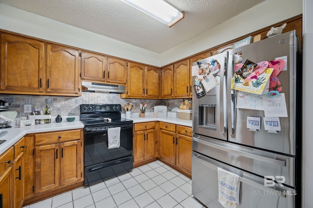 kitchen with black range with electric cooktop, under cabinet range hood, stainless steel fridge with ice dispenser, light countertops, and brown cabinets