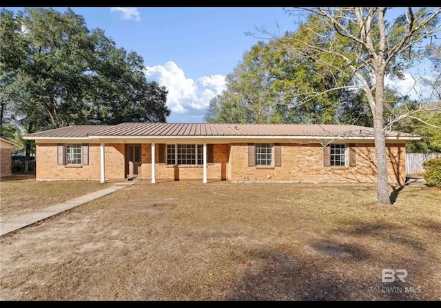 ranch-style house featuring metal roof and brick siding