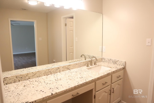 bathroom with baseboards, visible vents, and vanity