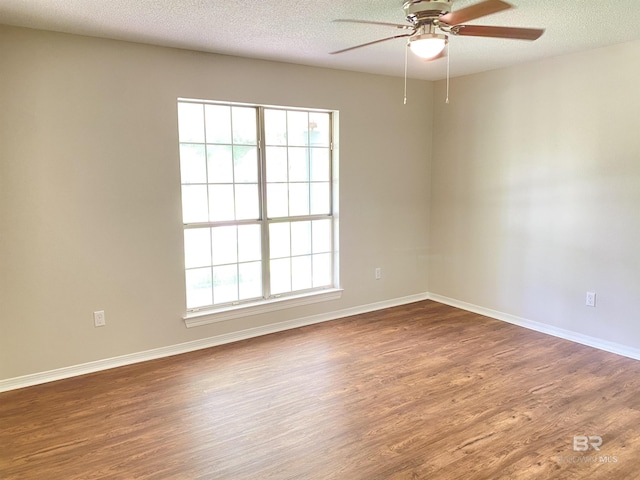 empty room featuring baseboards, a textured ceiling, ceiling fan, and wood finished floors