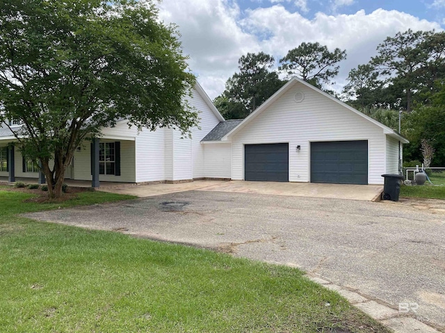 exterior space with a lawn, an attached garage, and driveway