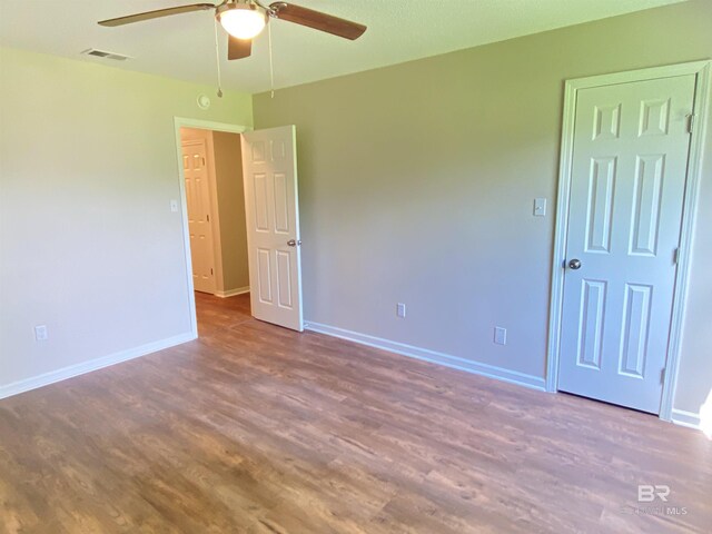 unfurnished room featuring baseboards, ceiling fan, visible vents, and wood finished floors