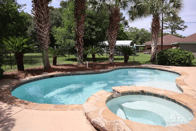 view of swimming pool featuring fence and a pool with connected hot tub