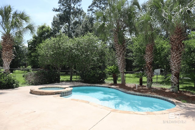 view of swimming pool with a patio, fence, and a pool with connected hot tub