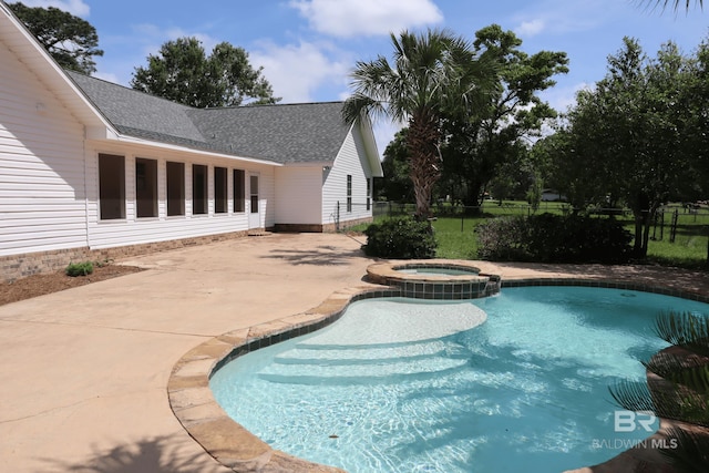 view of pool featuring a patio area, fence, and a pool with connected hot tub