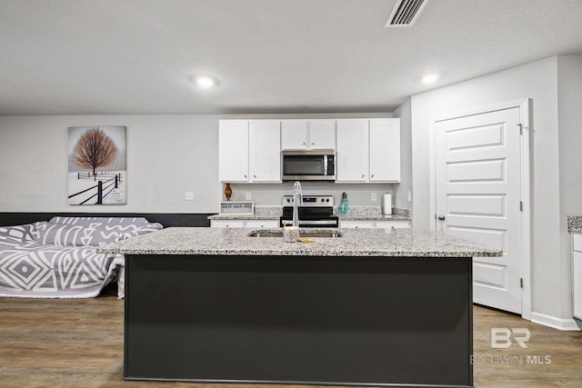 kitchen featuring stainless steel appliances, a kitchen island with sink, sink, dark hardwood / wood-style floors, and white cabinetry